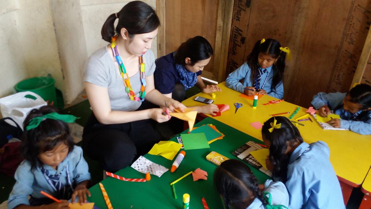 International volunteer teaching arts & crafts to the children at public shcools in nepal